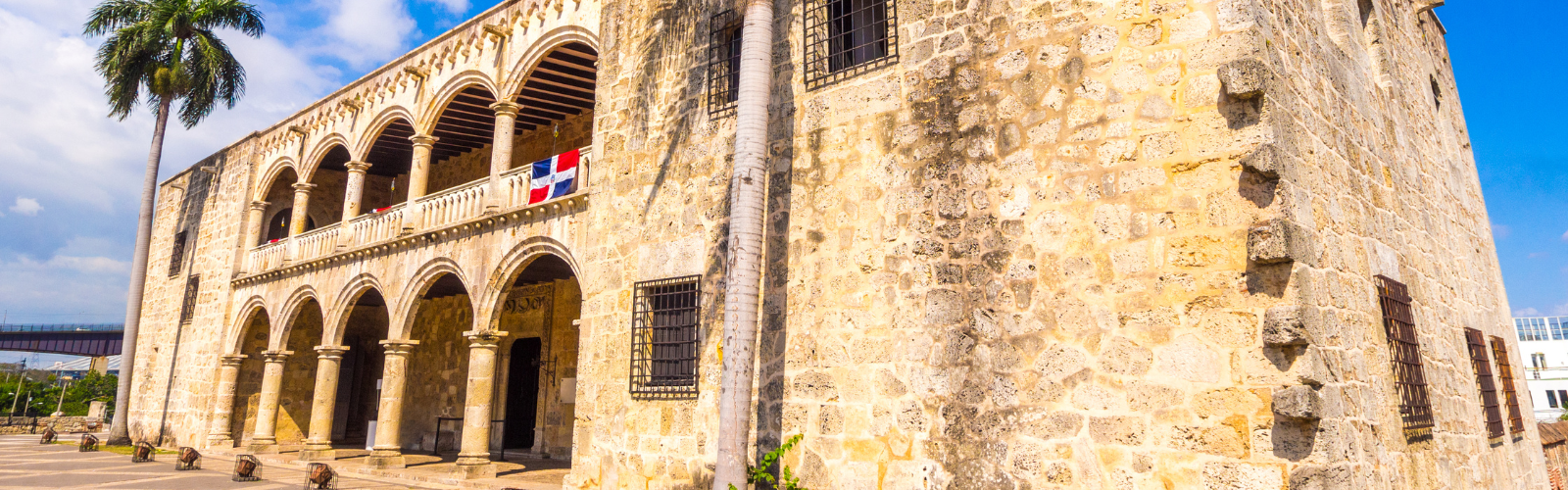 Outside of an old building with the Dominican Republic flag on the side. 